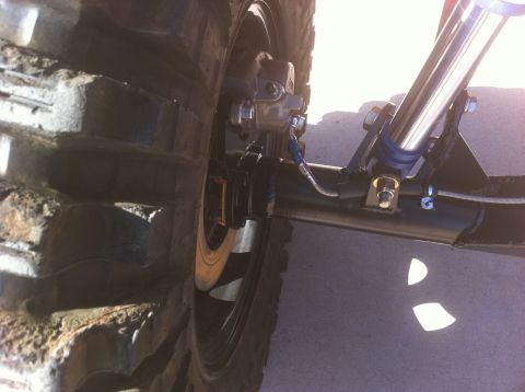 Suzuki Samurai - Detail shot of the rear axle and suspension system, including the brake caliper and shock absorber.