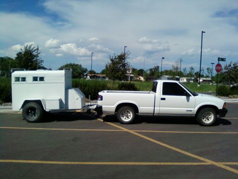 2006 Ford E350 - White pickup truck towing a white enclosed trailer in a parking lot.