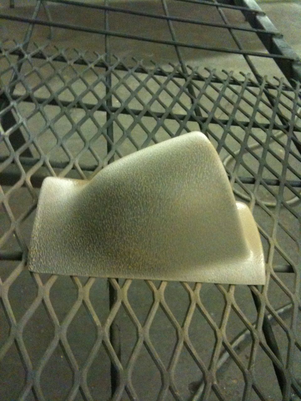 Tan plastic gauge pod on a metal grate