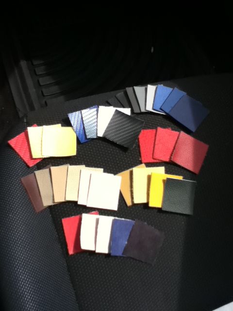 2006 Ford E350 - Various material samples are displayed on the dark textured seat of a vehicle, likely for interior trim options.