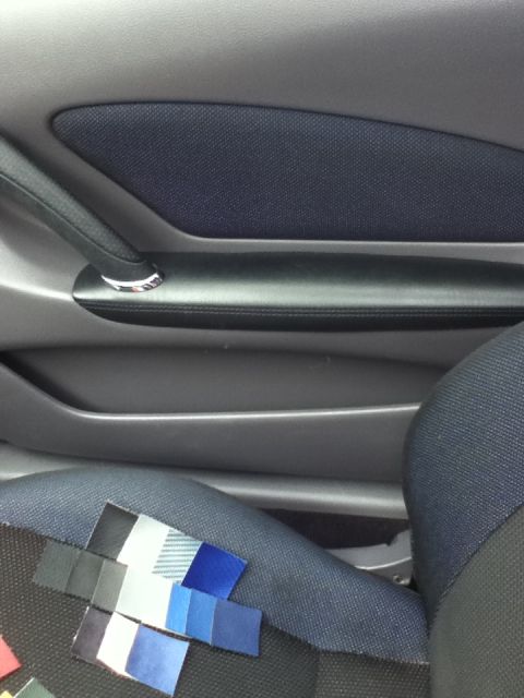 2006 Ford E350 - Fabric swatches are laid out on the seat of a vehicle, next to the interior door panel.