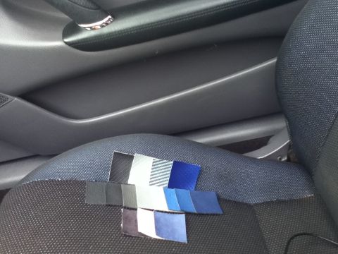 2006 Ford E350 - Swatches of fabric are laid out on a car seat, with the interior door panel visible in the background.