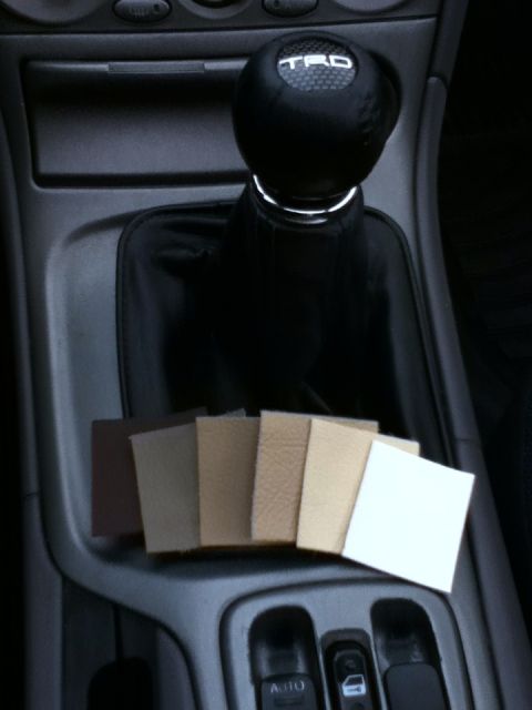 2006 Ford E350 - Fabric swatches are displayed in a car's center console near the gear shifter.