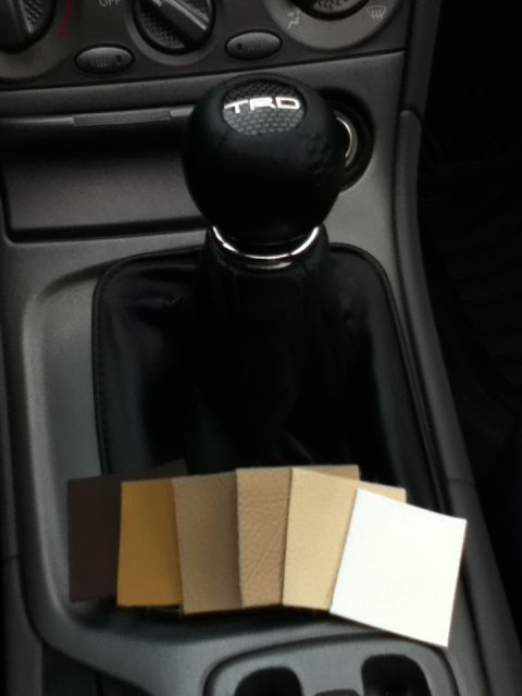 2006 Ford E350 - Interior view of a vehicle's center console, displaying a TRD shift knob and various material samples for comparison.