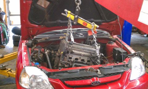 1999 Ford Expedition - Engine removal in progress on a red car.