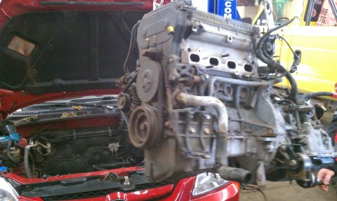1999 Ford Expedition - Engine removal in progress from a red vehicle.