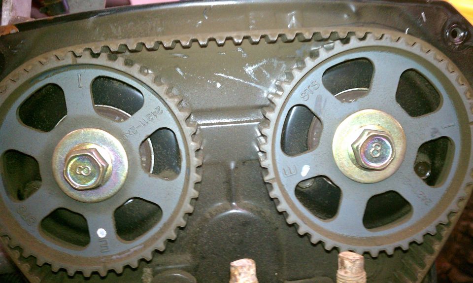 Close-up of two engine timing gears with a timing belt