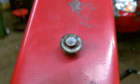 1999 Ford Expedition - A close-up view of a bolt on a red surface, with a watermark visible.