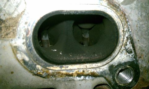 1999 Ford Expedition - Close-up of a dirty engine cylinder head, showing internal wear and carbon deposits.