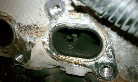 1999 Ford Expedition - Close-up view of a dirty exhaust manifold port, showing signs of wear and tear.