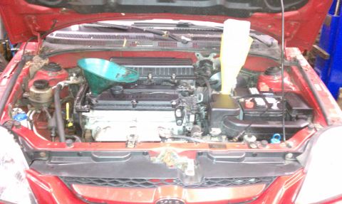 1999 Ford Expedition - The engine bay of a red car is shown with maintenance tools, contradicting the 1999 Ford Expedition claim.