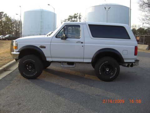 1996 Ford Bronco - Side view of a white 1996 Ford Bronco with aftermarket wheels and tires.