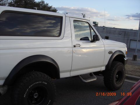 1996 Ford Bronco - Side profile of a white 1996 Ford Bronco with aftermarket wheels and tires.