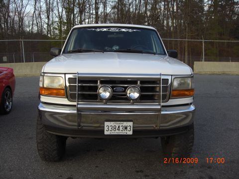 1996 Ford Bronco - Front view of a white 1996 Ford Bronco, equipped with a chrome bull bar and auxiliary lights.