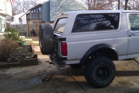 1996 Ford Bronco - Rear view of a white Ford Bronco, showing the spare tire mounted externally. The vehicle appears to be from the early to mid-1990s.