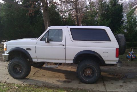 1996 Ford Bronco - White 1996 Ford Bronco lifted with off-road tires parked outdoors.