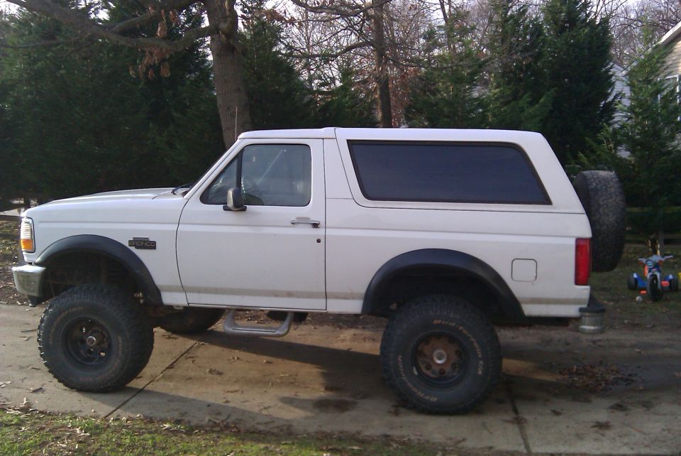 White 1996 Ford Bronco lifted with off-road tires, side view