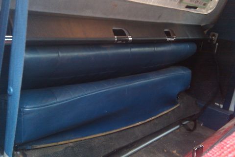 1996 Ford Bronco - The interior of a vehicle features blue upholstered seats and a dark upper dashboard panel.