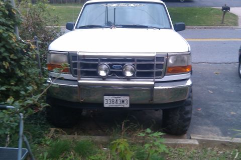 1996 Ford Bronco - Front view of a white Ford F-150 pickup truck parked outdoors.