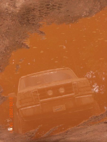 1996 Ford Bronco - This 1996 Ford Bronco is deep in an orange mud puddle, showing its rear end.