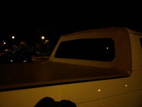 1996 Ford Bronco - The rear soft top of a vehicle is visible at night, with streetlights in the background.