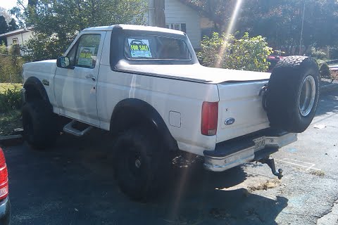 1996 Ford Bronco - This 1996 Ford Bronco features a soft top and a spare tire mounted on the rear bumper.