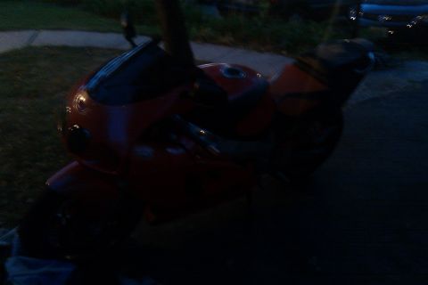 1996 Kawasaki Ninja R - A red motorcycle is partially visible in this dimly lit photo.