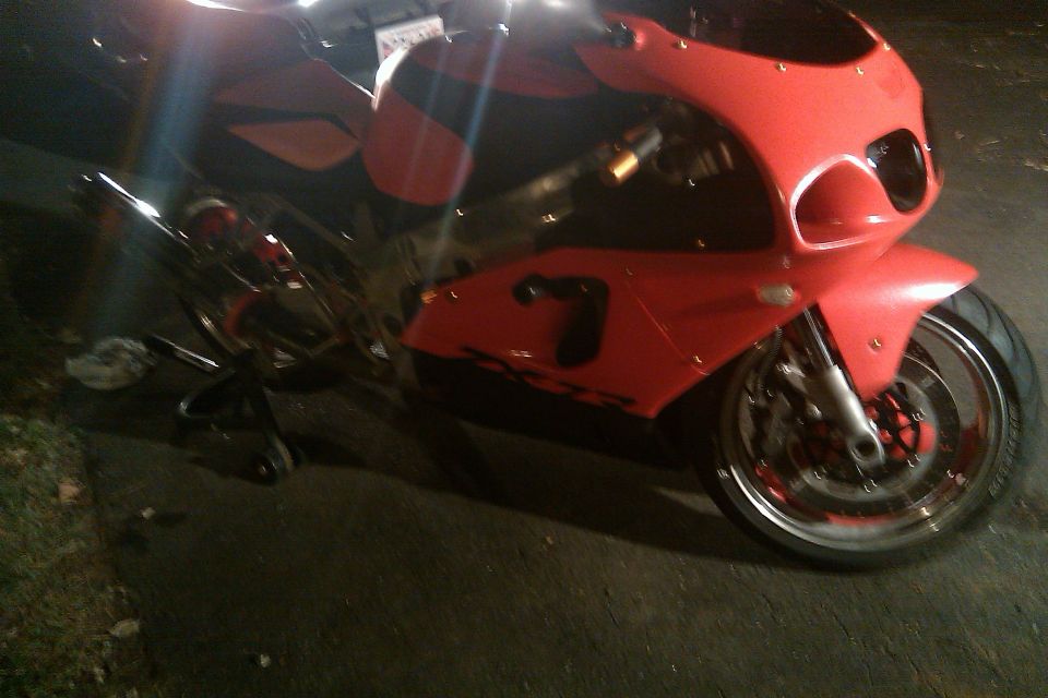 Red motorcycle with number 7 on the side, 3q-front view