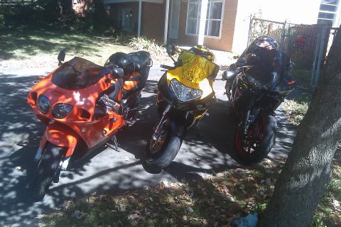 1996 Kawasaki Ninja R - Three sport motorcycles are parked in a driveway on a sunny day.