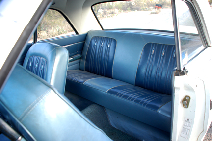 1965 Ford Fairlane - Interior view of a 1965 Ford Fairlane, its blue vinyl bench seats and door trim.