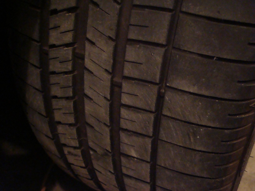 Close-up of a tire tread with visible wear and a Supermotors.net watermark