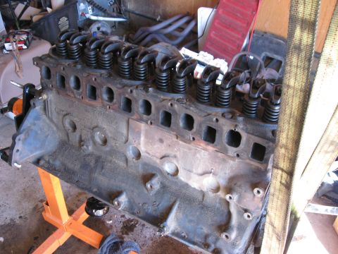 1981 Ford Bronco - Close-up of a V8 engine block with valve springs visible, resting on an orange engine stand.