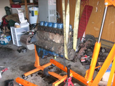 1981 Ford Bronco - An engine is shown on an orange engine stand, ready for installation or removal.
