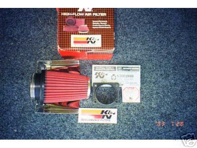 2002 Ford Taurus - A K&N High-Flow Air Filter kit is laid out on a carpeted surface with its packaging and instructions.