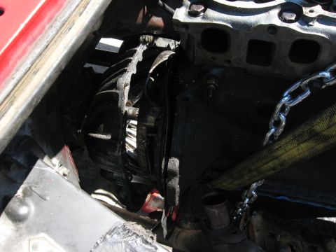 1981 Ford Bronco - Close-up view of a vehicle's engine and transmission assembly, secured with chains and straps.