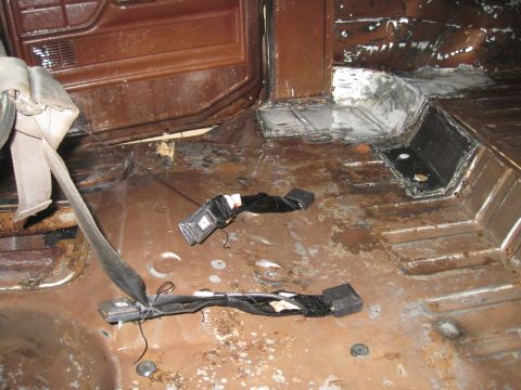 1979 Ford Bronco - The interior floor of the vehicle shows significant rust and appears to be undergoing some form of repair or restoration.