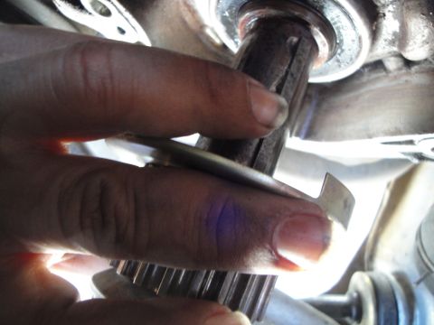1995 Ford Taurus - Close-up of a hand holding a splined metal gear, likely a car part.
