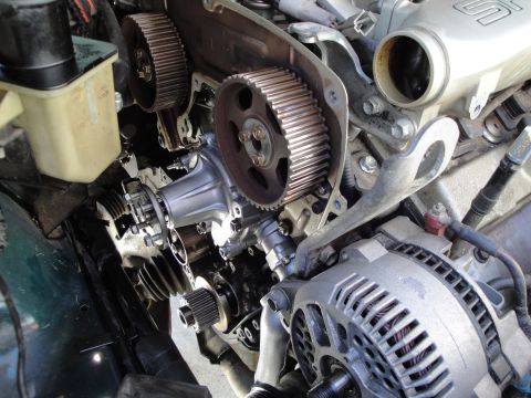 1995 Ford Taurus - Close-up view of engine components, including timing gears, water pump, and alternator.