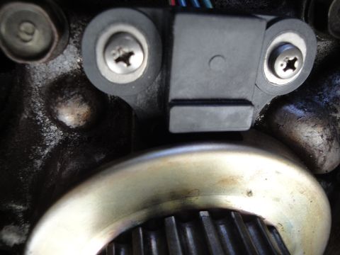 1995 Ford Taurus - Close-up of a crankshaft position sensor and its associated timing gear.