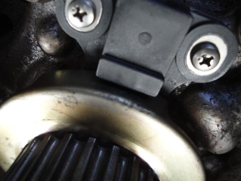 1995 Ford Taurus - A crankshaft position sensor is shown mounted near a toothed wheel, likely part of an engine's timing system.