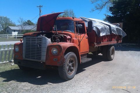 2000 Mercury Grand Marquis - This orange dump truck, with its hood open and bed covered by a tarp, is parked outdoors.