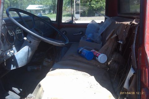 2000 Mercury Grand Marquis - The interior of a vintage truck cab shows a worn seat and dashboard with various items scattered inside.