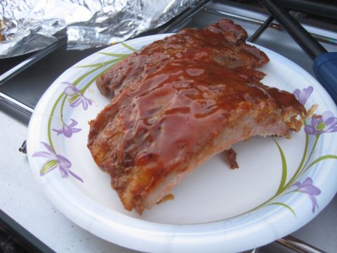 1989 Ford Bronco - A plate of ribs glistening with barbecue sauce sits on a table, possibly at an outdoor event.