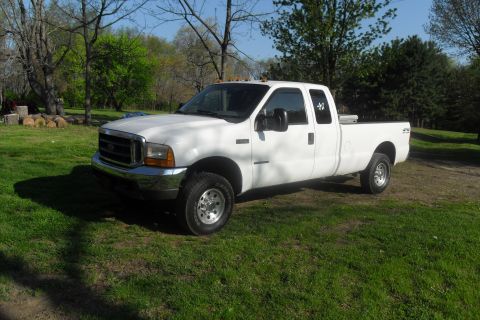 2000 Ford F-250 - This white 2000 Ford F-250 pickup truck is parked outdoors on a sunny day.