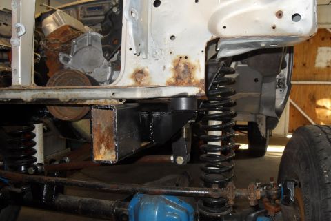 1997 Ford Ranger - Close-up view of a truck's chassis, highlighting suspension components, engine parts, and signs of rust and repair.