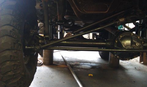 1996 Ford Bronco - Close-up of vehicle undercarriage, focusing on suspension and drivetrain parts.