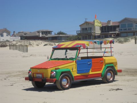 1989 Ford Bronco - A brightly colored Volkswagen Thing sits on the sand near beach houses.