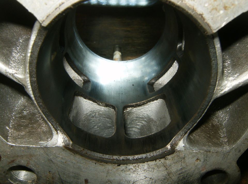 Close-up of an engine cylinder bore with visible honing marks and transfer ports