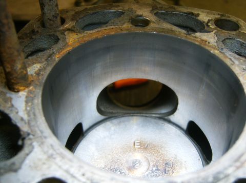 2000 Ford E350 - Close-up down into a two-stroke cylinder with the head removed, showing the piston near the top of the bore, the large bridged exhaust port…