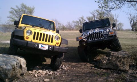 2005 Jeep Wrangler - Two Jeep Wranglers navigate a rocky terrain on a sunny day.
